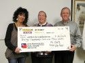 Interfaith Check held by Maryann Curmi, Cathie Peacock, and Larry England