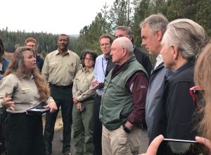 Ag Secretary Perdue (green vest) and Interior Secretary Zinke (directly behind) speak with Forest Service officials in Paradise