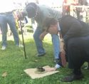 Borgeas on right sizes up a frog at the 45th Annual Capitol Frog Jump
